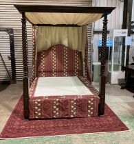 A contemporary mahogany four poster bed with twisted front columns, with well embroidered drapes and