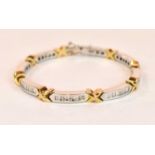 An 18ct white and yellow gold diamond line bracelet set with a mixture of round brilliant cut and