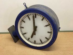 An early 20th century double sided industrial wall clock with metal and glazed case, opaque glass