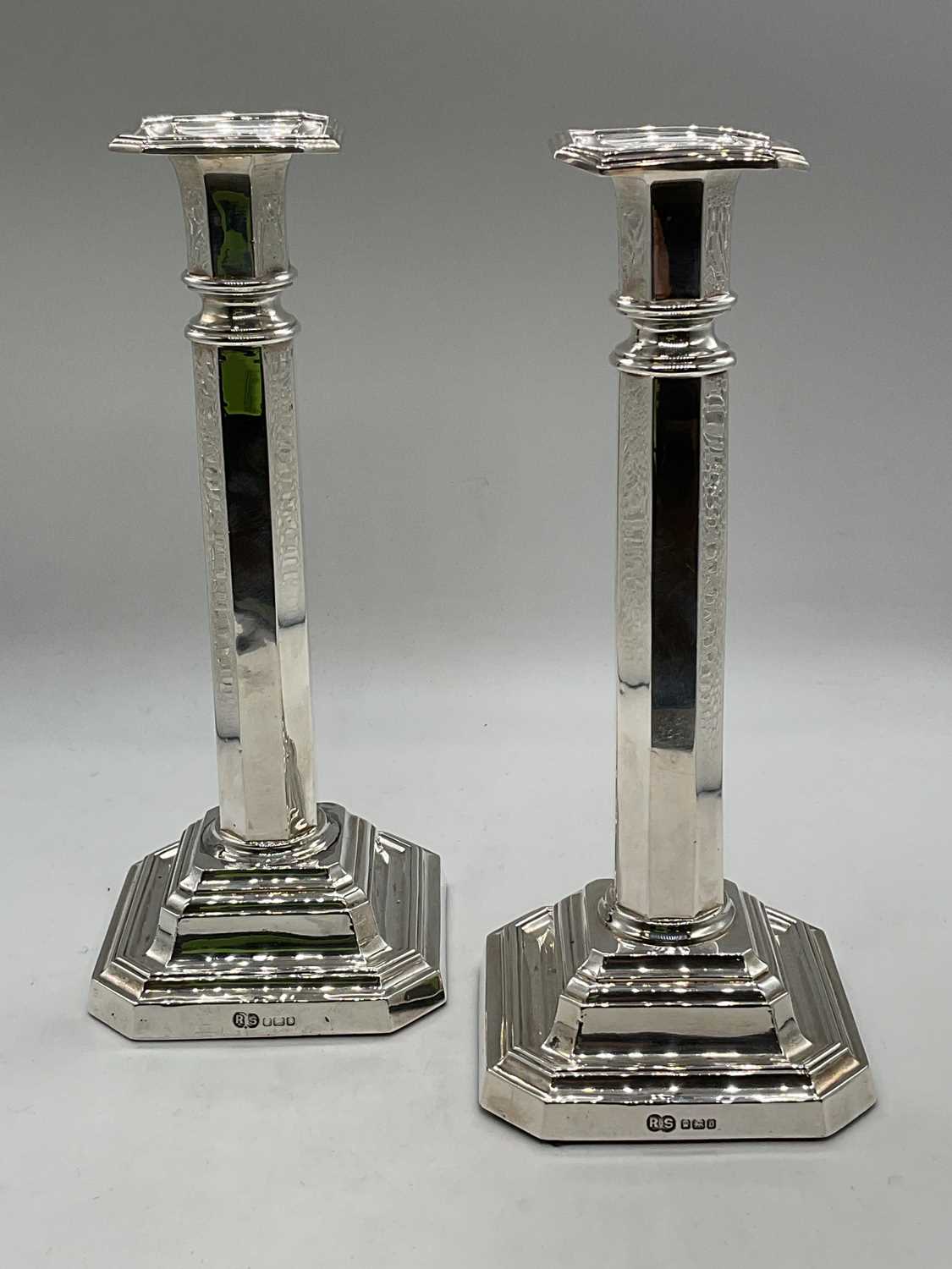 A pair of Edwardian hallmarked silver candlesticks with fixed sconces, octagonal central columns