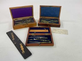 Three vintage cased sets of drawing instruments, also a slide rule.