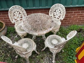 A white metal circular garden table with four chairs.