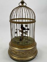 An early 20th century singing automaton single bird birdcage with scroll detail to the cylindrical