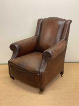 A late 19th century leather upholstered armchair, with studded details to the arms, back and