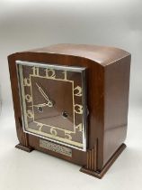 An Art Deco walnut mantel clock with Arabic numerals to the square dial and presentation plaque