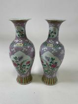 A pair of late 19th/early 20th century Chinese Famille Rose lilac ground baluster vases, each