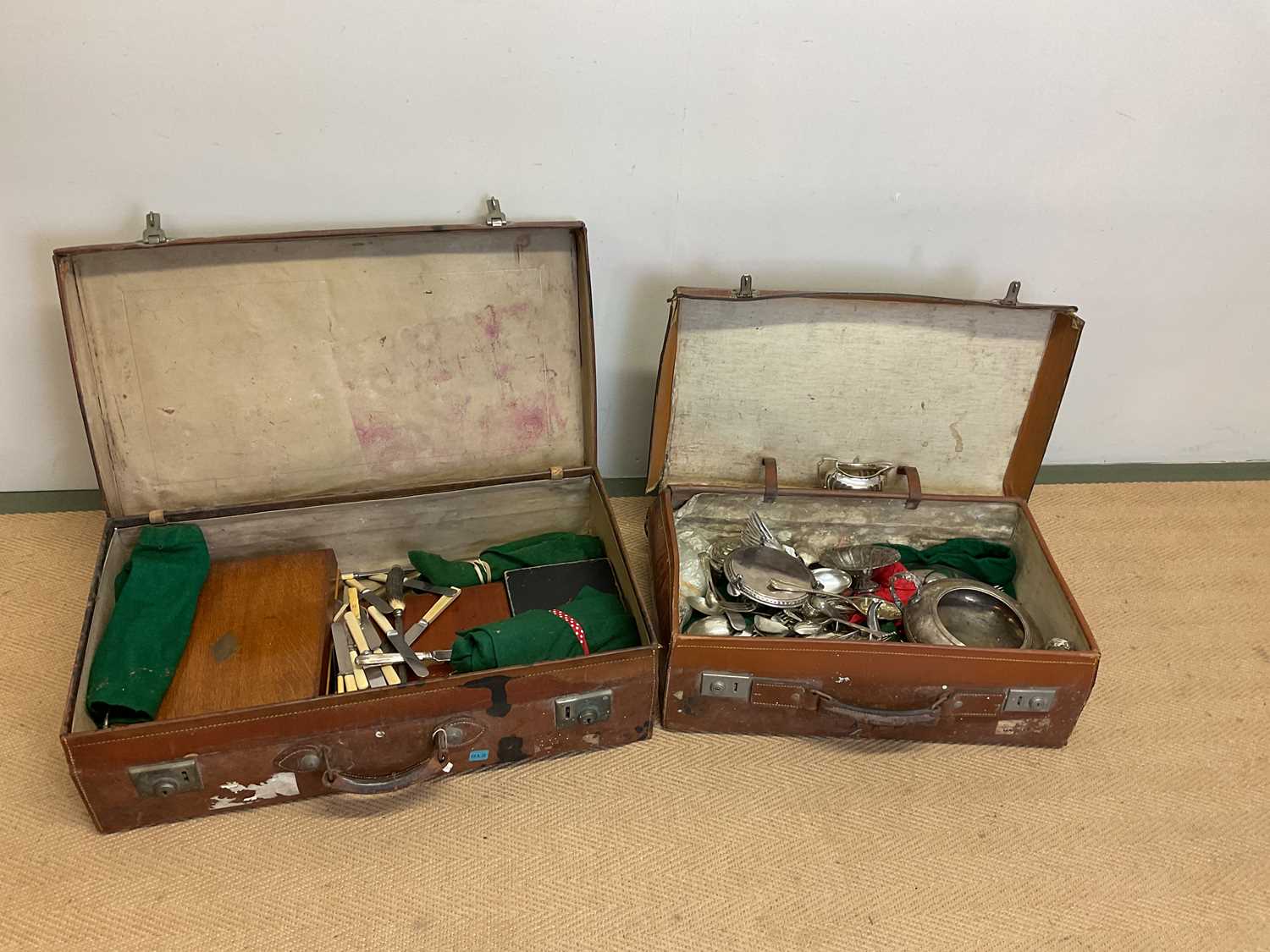 Two vintage leather suitcases containing silver plated items, including teapot, twin handled bowl,