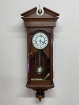 A contemporary oak wall clock, height 104cm, width 39cm