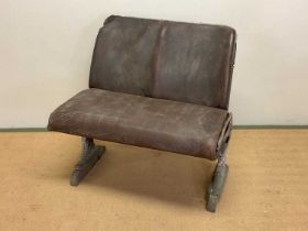 A pair of early 20th century tram seats, constructed of a metal frame with leather seat and back,