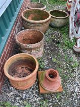 A quantity of terracotta garden pots, comprising five large pots and one stand which accommodates