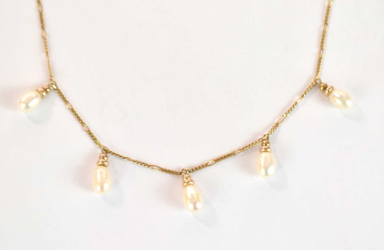 A 9ct yellow gold necklace set with five oval pearl drops, length 38cm, approx. 3.15g.