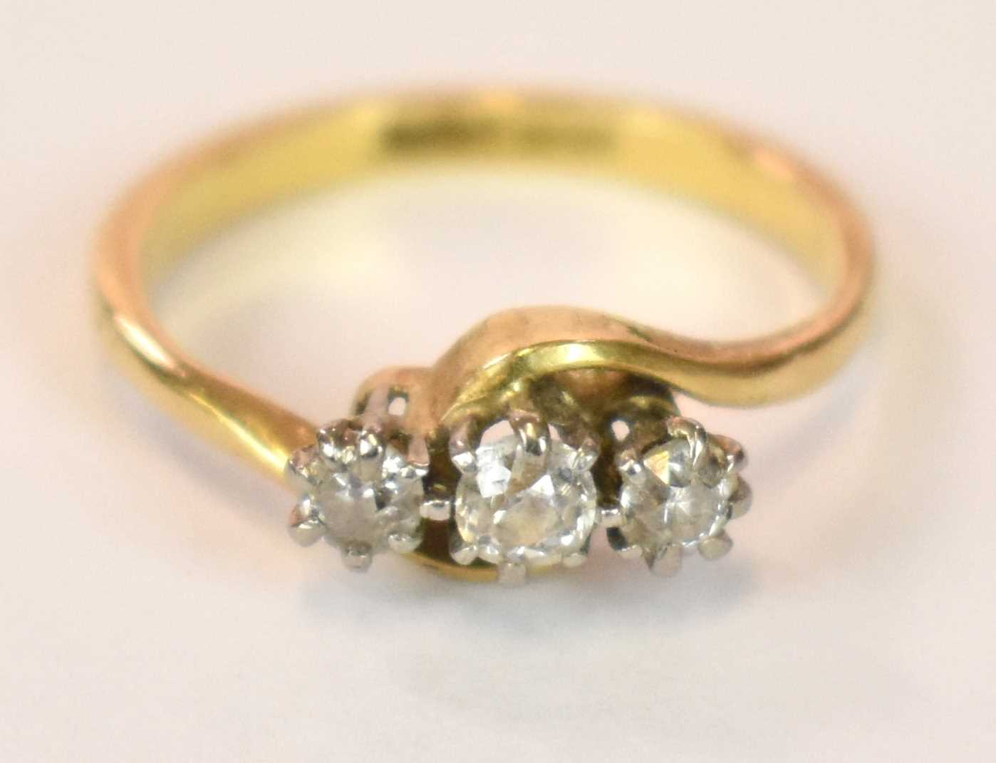 An 18ct yellow gold platinum tipped three stone diamond ring in swept setting, size J, approx. 3g.