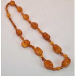 An early egg yolk/butterscotch amber bead necklace formed of six large beads, four medium sized
