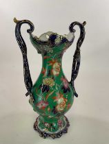 A large mid Victorian green glazed floral decorated twin handled vase and cover with leaf finial