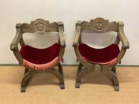 A pair of reproduction Savonarola chairs with carved front supports, arms and back with burgundy