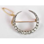 A circa 1900 yellow and white metal diamond set crescent brooch with twenty-three old cut