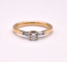 An 18ct yellow gold and platinum tipped diamond three stone ring, the central four claw set round