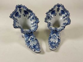 A pair of Dutch Delft shoes with elborate shaped rim, landscape painted and floral decorated main