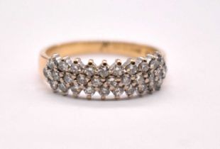 An 18ct yellow gold platinum tipped diamond ring set with three rows of round brilliant cut
