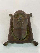 BONAPARTE INTEREST; a cast iron model of Napoleon Bonaparte's death mask set on a tasselled cushion,