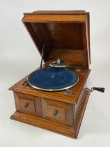 An early 20th century oak cased gramophone (unnamed), and a large collection of records.