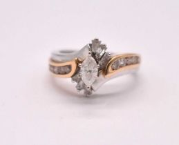 A 14ct yellow and white gold diamond cluster ring with raised six claw set marquise cut stone within