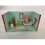 A model tin bathroom with water tanks and a removable bath, toilet and doll, in playworn