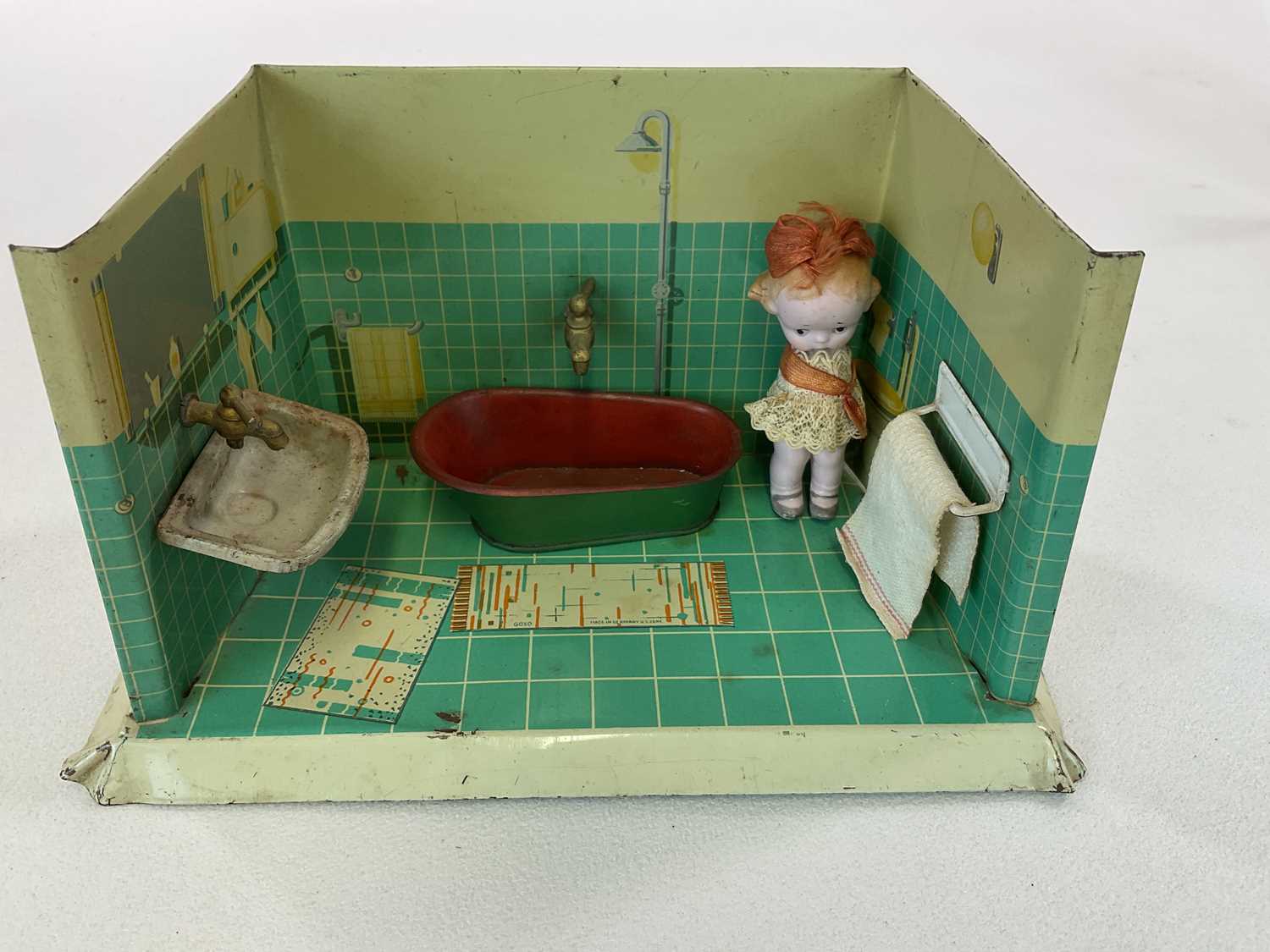 Tin bathroom with water tank, removable tin bath and china doll, in playworn condition, height 13cm,