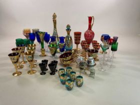 A large collection of coloured glassware, including green, blue, and red tinted examples.