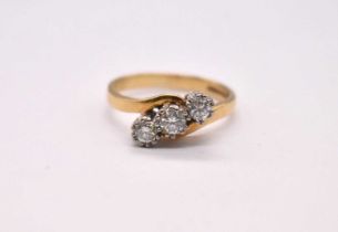 An 18ct yellow gold and diamond three stone ring in crossover swept setting, total diamond weight