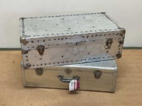 Two aluminium travelling cases with rivet detailing, larger height 25cm, width 76cm, depth 42cm.