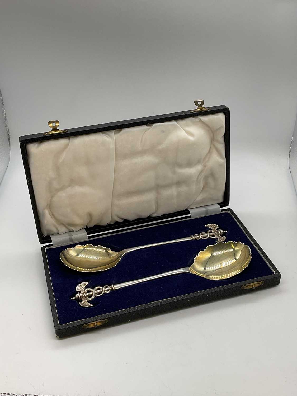 JAMES DEAKIN & SONS; a cased pair of George V hallmarked silver spoons with finials modelled as