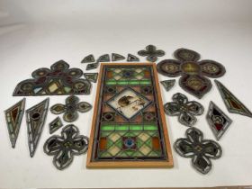 A collection of 19th century leaded stained glass, the largest panel set in pine frame and centred