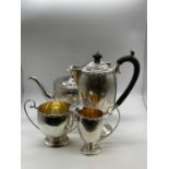 JOSEPH GLOSTER & CO LTD; a George V hallmarked silver four piece tea set, both pots with ebonised