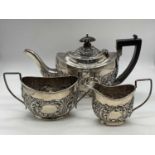 An Edwardian hallmarked silver and foliate embossed three piece tea set, Birmingham 1902, length