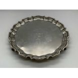 WALKER & HALL; a George V hallmarked silver salver of shaped circular form raised on scrolling