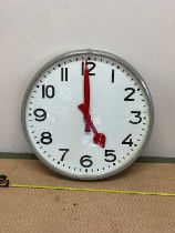 A mid 20th century industrial wall clock, with metal and glazed case with red hands, the dial with