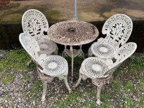 A white metal circular garden table with four chairs.