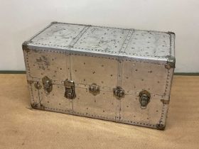 Aluminium travelling trunk with rivet detailing, height 56cm, width 102cm, depth 54cm.