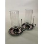 GARRARD & CO LTD; a pair of silver plated storm chamber sticks with glass funnels, dished bases