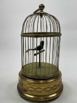 An early 20th century singing automaton single bird birdcage with scroll detail to the cylindrical