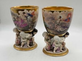 KPM; a pair of porcelain beakers, each with gilt washed interior, hand painted with classical