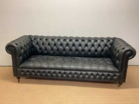 A late 20th century black leather Chesterfield sofa with button back detail and studded front raised