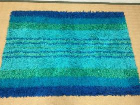 A 1960s Swedish Rya rug, with deep pile in various blue and green stripes, originally purchased by