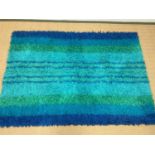 A 1960s Swedish Rya rug, with deep pile in various blue and green stripes, originally purchased by