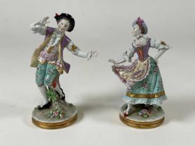 A pair of late 19th century Continental porcelain figures of a dandy and his companion, both