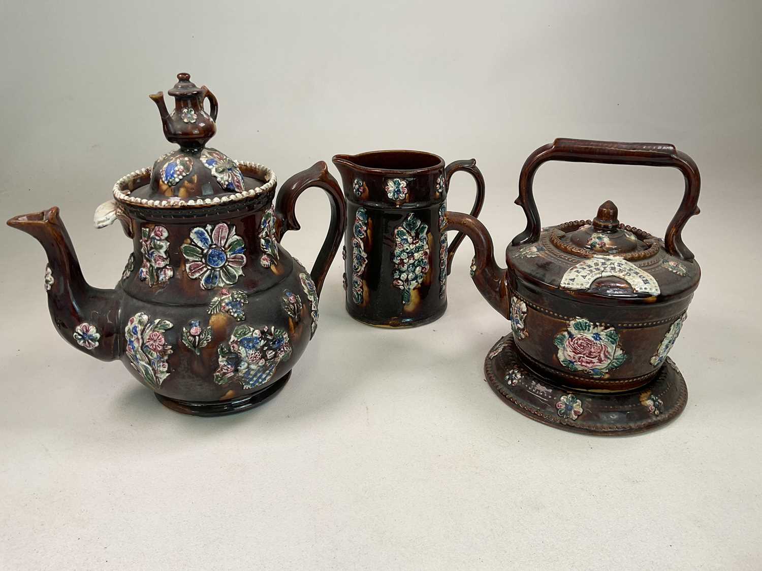 BARGEWARE; a glazed teapot, kettle on stand and jug of large proportions, height of teapot 32cm.