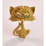 An 18ct yellow gold brooch in the form of a stylised cat with emeralds set for the eyes, length