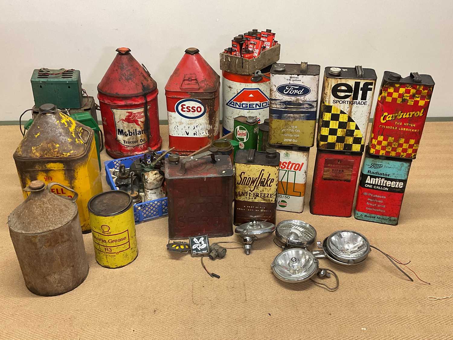 A collection of automobilia to include oil drums, oil cans, headlamps, badges, for Elf, Shell,