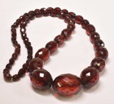 A vintage cherry amber graduated facet cut bead necklace, length approx 80cm, largest bead approx